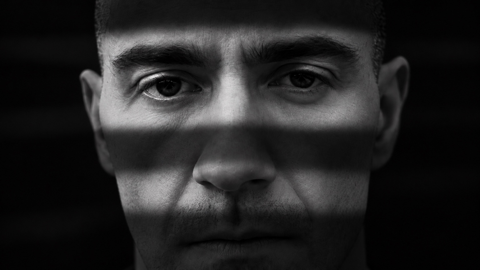 Thumbnail do vídeo: retrato de Douglas em preto e branco com faixas de luz e sombra
